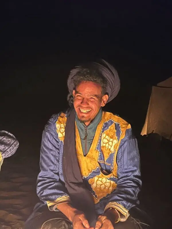 Hamza smiling under the stars – Sahara chamelier at night