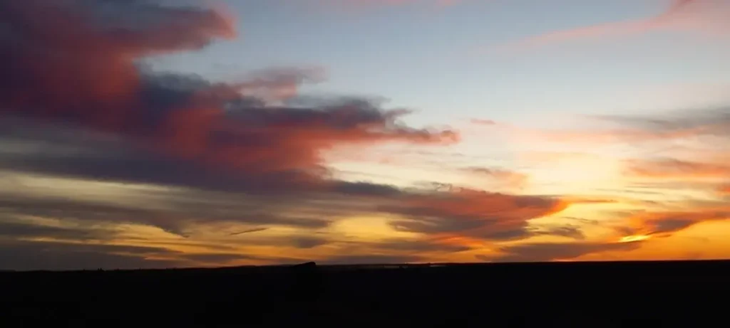 Spectacular sunset over the golden Sahara dunes, with warm and soft hues painting the sky.