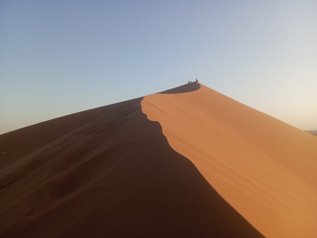 trekkeurs au sommet dune Erg Zahar au coucher de soleil trek désert Sahara Maroc 6 jours