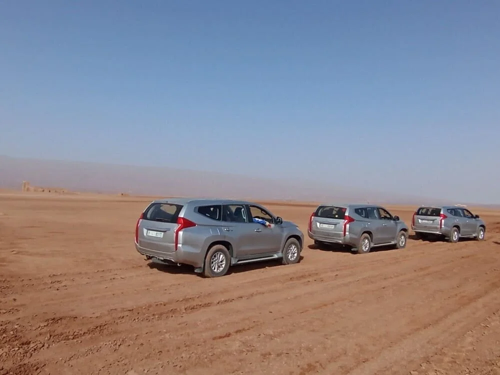 Convoy of 4x4 vehicles crossing desert tracks in the Moroccan Sahara during a 6-day journey with ADN Sahara