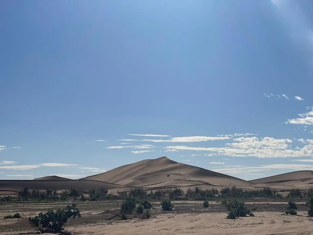 petit 4x4 traversant les dunes immenses de l’erg Chegaga, Sahara marocain